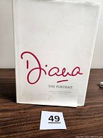 Front cover of 'Diana The Portrait' showing white dust jacket with red cursive title and visible wear.
