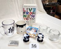 Full view of the lot items including book, mugs, tumbler, shot glass, and paperclips.