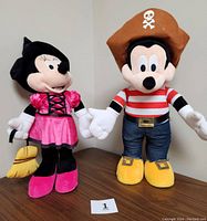 Front view of Mickey and Minnie Mouse plush door greeters, showing detailed costumes and facial features