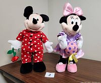 Front view of Mickey Mouse in red pajamas holding rose and Minnie Mouse in pink and purple dress holding Easter egg