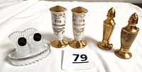 Front view of all three sets of salt and pepper shakers displayed on a white surface with auction lot number.