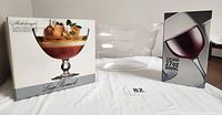 Photo of boxed Luigi Bormioli Michelangelo serving bowl, clear acrylic cooler, and boxed Kovot XL wine glass