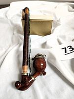 Front view of the vintage alpine smoking pipe showing wooden stem, polished double bowls, and metal lids.