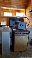 Three items grouped: amplifier front, fog machine on top, speaker at left