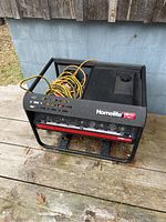 Front and angled view of the Homelite LR14400 generator showing the metal frame, fuel tank, and control panel with outlets.