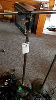 Two adjustable metal mic stands with round bases viewed from front