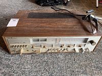 Front and top view of vintage Sears solid state receiver showing woodgrain casing, tuning dial, sliders, and antenna.