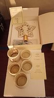 Lenox tree topper star and four matching tealight candle holders displayed in packaging with paperwork.