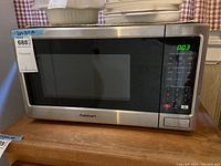 Full front view of Cuisinart microwave on wooden surface with digital display lit showing 0:03.