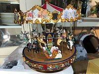 Front view of the mechanized musical carousel showing horses, tiger, and swan sleigh figures with ornate decorations