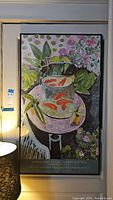 Full view of framed poster showing goldfish in a bowl, plants, and flowers on table.