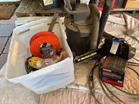 Wide view showing McCulloch 14-inch chainsaw, Craftsman 6 gallon shop vac, and plastic bin with cords and trouble light.