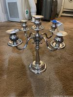 Silverplate 5-arm candelabra standing on carpet floor.