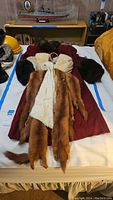 Long vintage brown fur coat laid flat showing attached fur pelts.