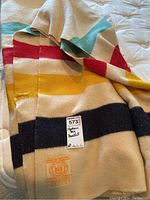 Folded wool blanket showing colorful stripes and Hudson Bay label.