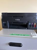 Front view of the black Canon Pixma G4200 printer showing brand name, model label, and refillable ink tanks with four ink colors.