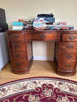 Front view of the vintage wooden desk with multiple drawers and clutter on top removed in listing description.