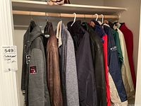 Seven jackets hung on closet rod showing full lot