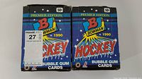Two unopened blue cardboard boxes labeled 'Bowman Hockey Premier Edition 1990' with visible wear and price tags on top.