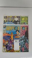 Four comic books stacked with issues 1 and 2 visible, minor to moderate wear shown