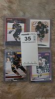 Four Mario Lemieux hockey cards laid out on a surface, showing a mix of action poses in Pittsburgh Penguins uniform.