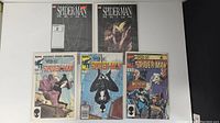 All five comics laid out: 2 Spiderman Reign issues top row, 3 Web of Spiderman issues bottom row including double-sized annual and one with Venom