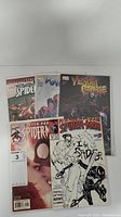 Five Spiderman comic books displayed upright showing various covers including Venom Carnage and Peter Parker The Spectacular Spider-Man.