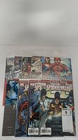 Full view of all 9 Spider-Man related comic books fanned out on the surface