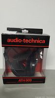 Full view of Audio Technica ATH-909 headphones inside the original retail box with clear plastic window showing the headphones.