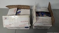 Two slightly opened USPS Priority Mail boxes filled with loose baseball cards, showing the large quantity and packaging of the lot.
