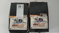 Two black cardboard boxes labeled 'Pro Set' containing hundreds of hockey cards shown from top-down angle. Boxes show wear and tear but appear filled and intact.