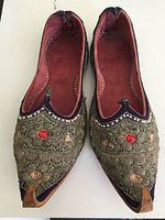 Top-down view of the pair of antique Indian shoes showing the beadwork floral pattern and red inner lining.