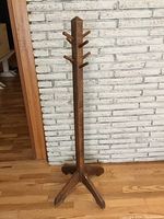 Front view of the solid wood coat rack showing height, base, and pegs for hanging