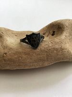 Antique sterling silver shield ring with black enamel and decorative initials, showing design details and condition.