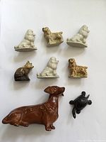 Top-down view of all nine figurines arranged on a flat surface showing color, size and shape variety.