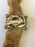 Front side view of the sterling silver bird brooch showing detailed stylized bird design and rounded corners.