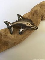 Front angled close-up showing the dolphin shape and overall condition.