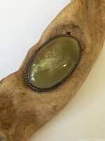 Front view of the vintage sterling silver brooch showing oval green agate stone set in twisted rope design bezel.