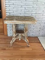 Front view of Victorian parlour table showing chipped paint and decorative legs