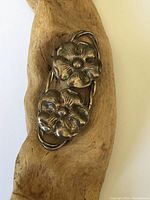 Close-up of the sterling silver flower brooch showcasing two detailed flowers with five petals each and the twisted wire frame shape.