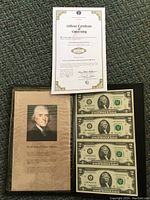 Four uncirculated $2 bills in a folder with Thomas Jefferson portrait and wisdom quote alongside official certificate of ownership.