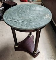 Round green granite top with natural pattern and wear marks.