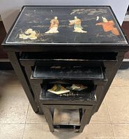 Top view showing mother of pearl inlaid figures and painted gold landscape on the largest table, with three smaller tables nested below