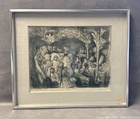 Framed etching artwork in silver frame placed against a wall, showing full piece including mat and artwork details.