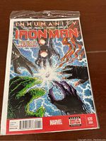 Front cover of Iron Man comic book, Vol. 5 Issue 20, showing art from the Inhumanity storyline with vibrant colors and several character hands reaching toward a glowing orb.