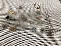 Full view of all costume jewelry items laid out on fabric, showing earrings, brooches, necklace with chain and pendant