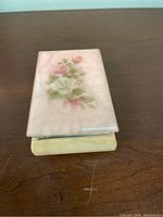 Alabaster trinket box closed, showing pink marbled lid with floral design and beige base