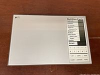 Top view of digital nutrition food scale with nutrition facts and keypad.
