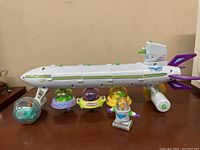 Wide view of the 2001 McDonald's Buzz Lightyear Star Command Happy Meal spaceship with four pod character figures and one small Buzz Lightyear figure in front.