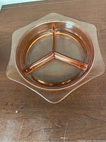 Top view of pink Depression glass hexagon-shaped dish with three compartments.